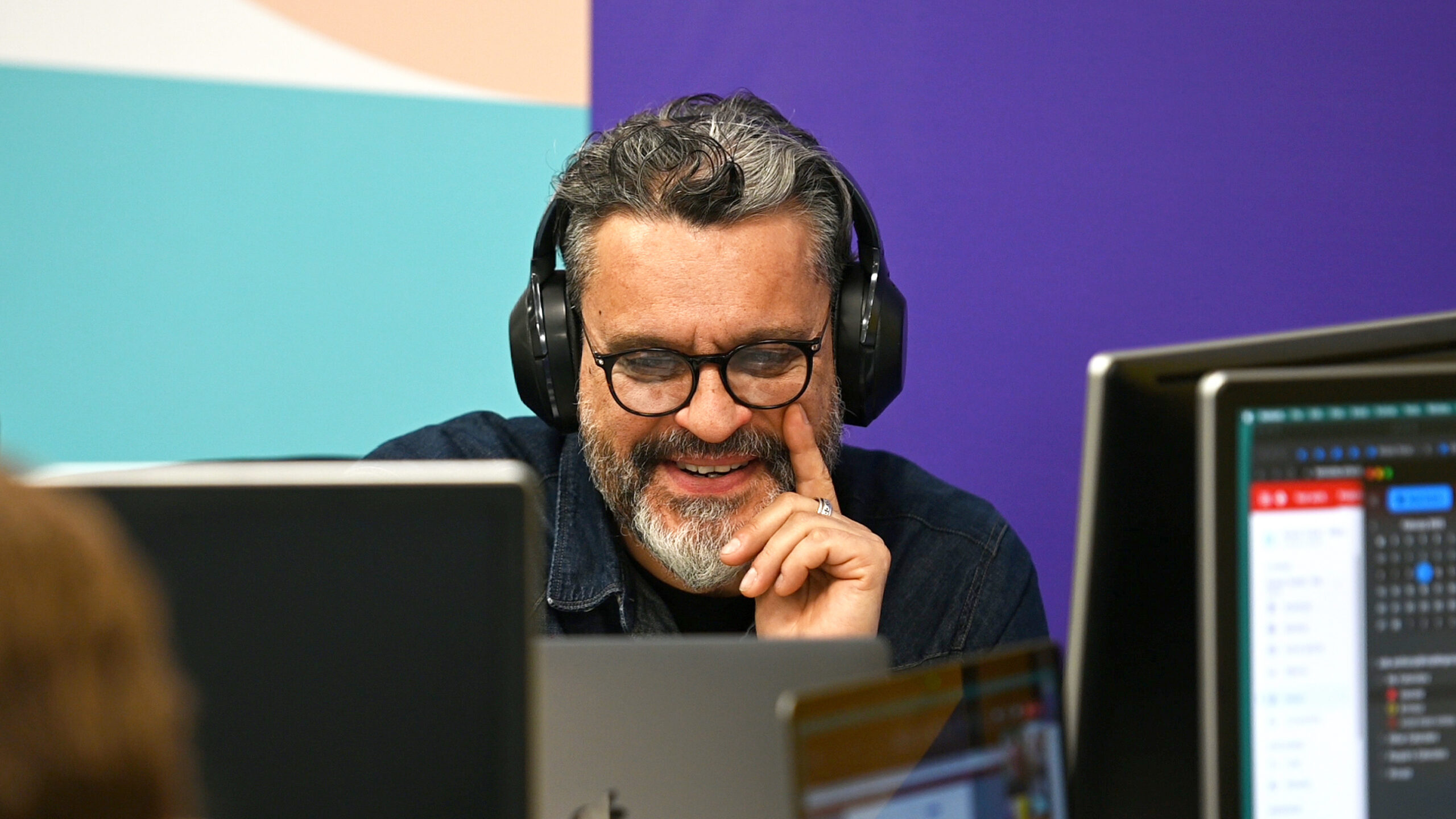 A man looking at a computer screen and smiling